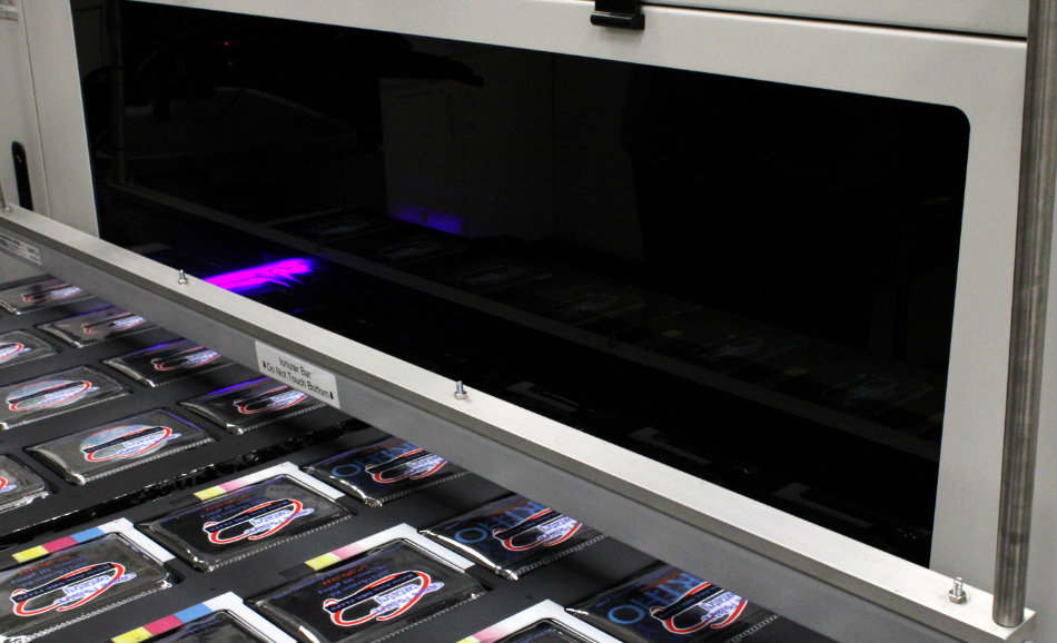 closeup on kit bags going through our new full-color digital printer